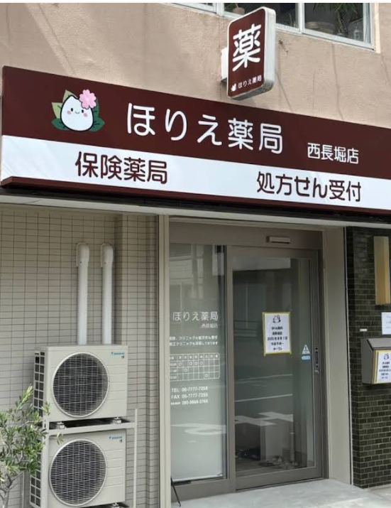 ほりえ薬局 西長堀店の外観。小豆色の看板に「ほりえ薬局」「保険薬局」「処方せん受付」の文字